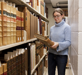 Special Collections Librarian, Meaghan Scanlon, holding a rare book in her hands.