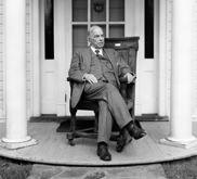 Black-and-white image of William Lyon Mackenzie King sitting on his front porch.