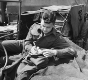 Black-and-white photograph a man at war writing a letter