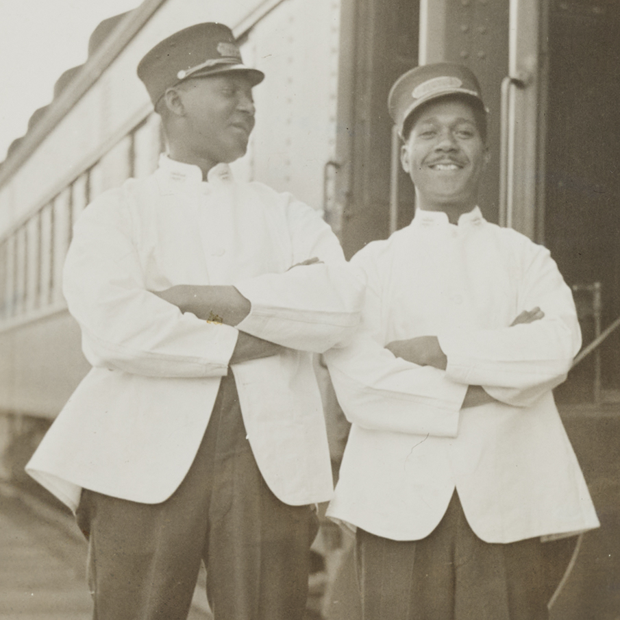 L-R Railway porters Smitty from Montréal and Albert Budd standing beside a train.