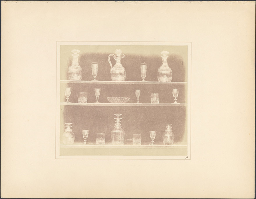 Three shelves with various different glasses and crystals.