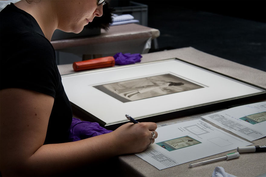 Woman writing a report beside a photograph.