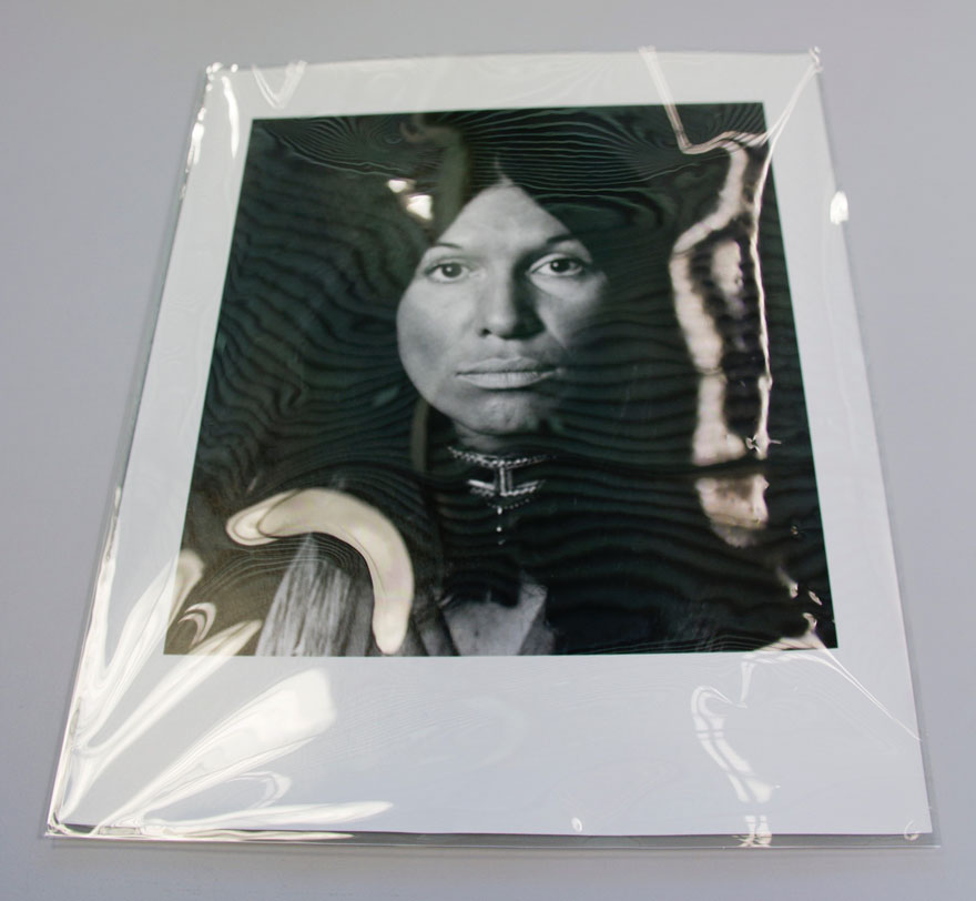 A photograph of a face of a First Nation's woman in a plastic sleeve.