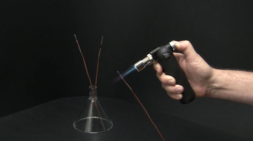 A copper wire is heated up with a torch. A green flame is generated.