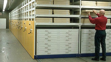 Photograph of the mobile shelving units used to store the “pizza boxes” used for oversize paper documents